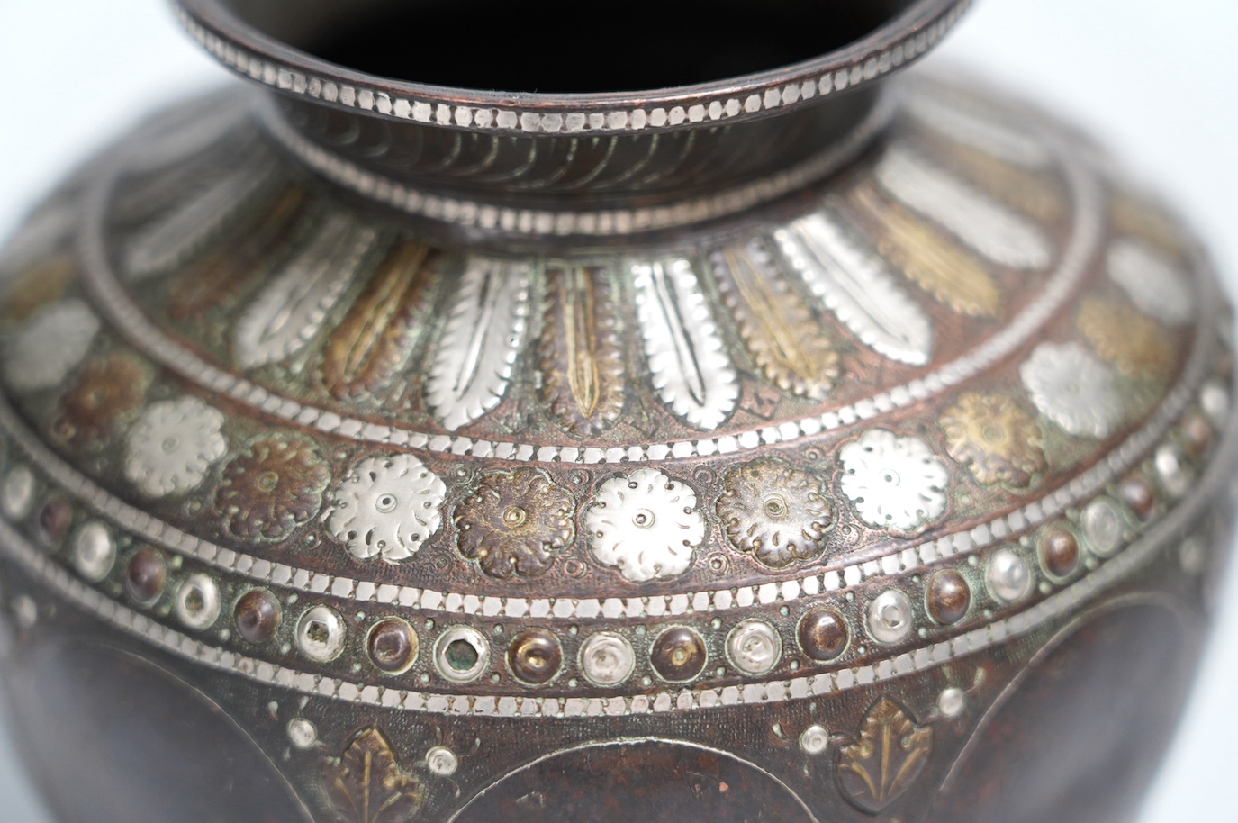 An Indian ganga jumna mixed metal water pot with engraved decoration, 14cm high. Condition - some dents